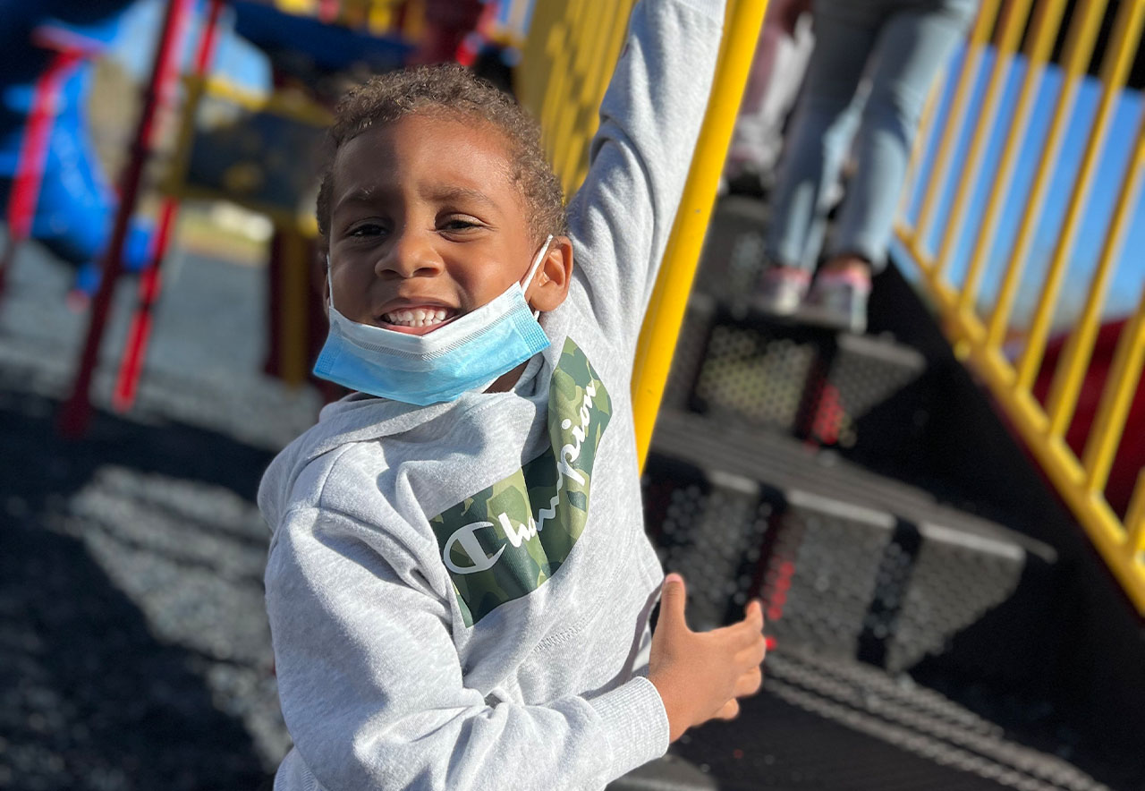 ocoee oaks preschool child smiling outside on playground
