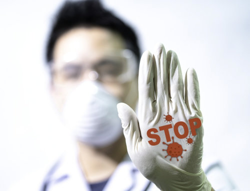 man with a mask holding his hand out with the word Stop on it